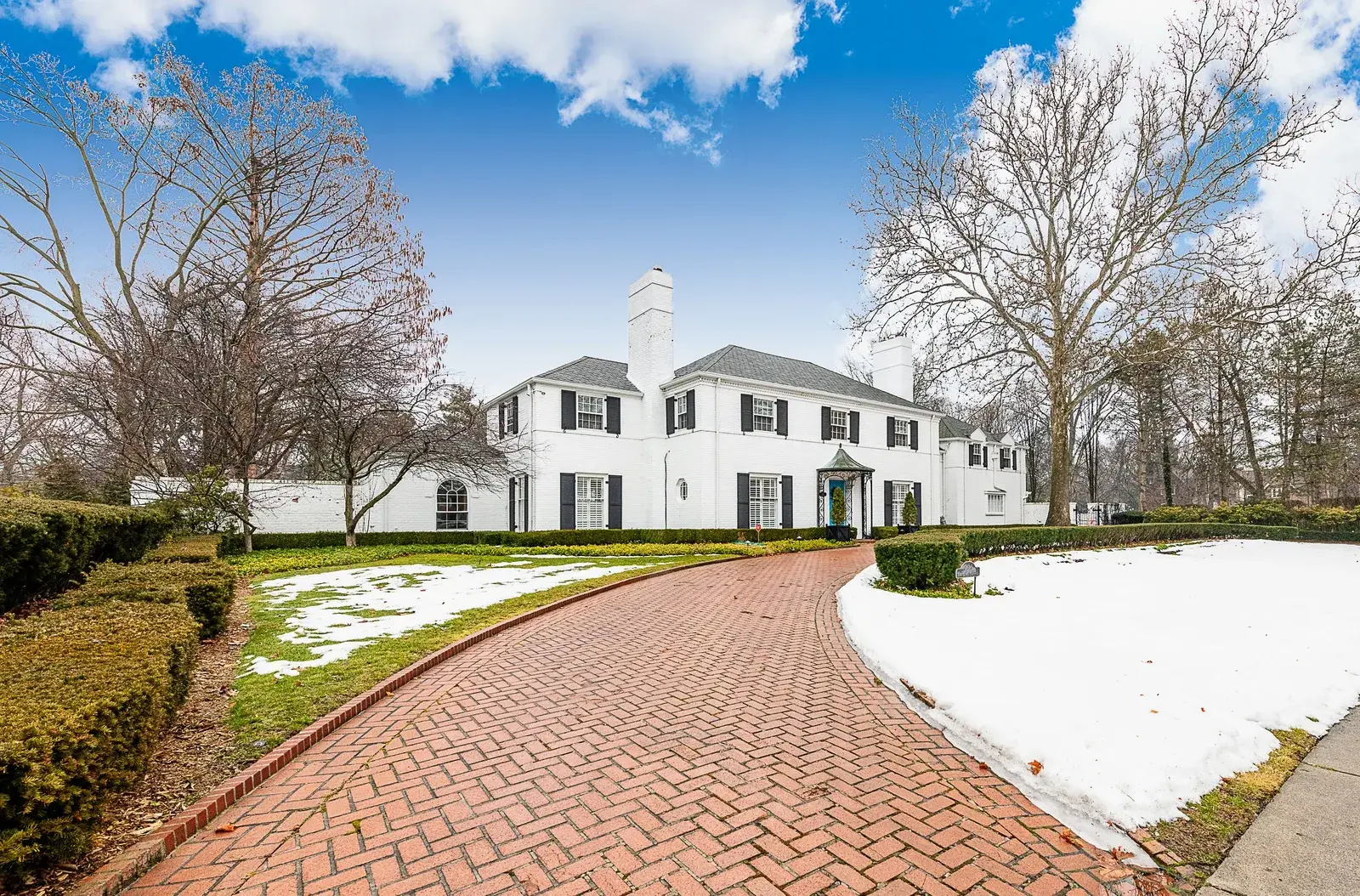 Driveway view of a large mansion-like home