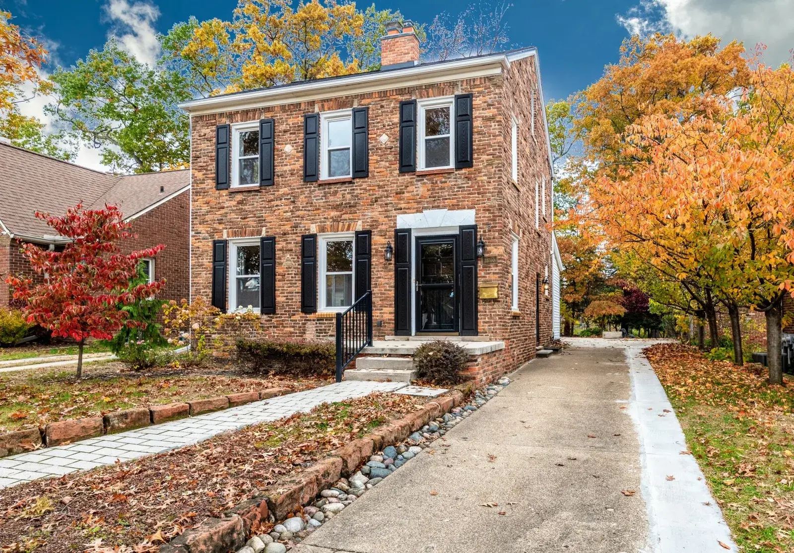 Front lawn view of a home surrounded by fall foliage