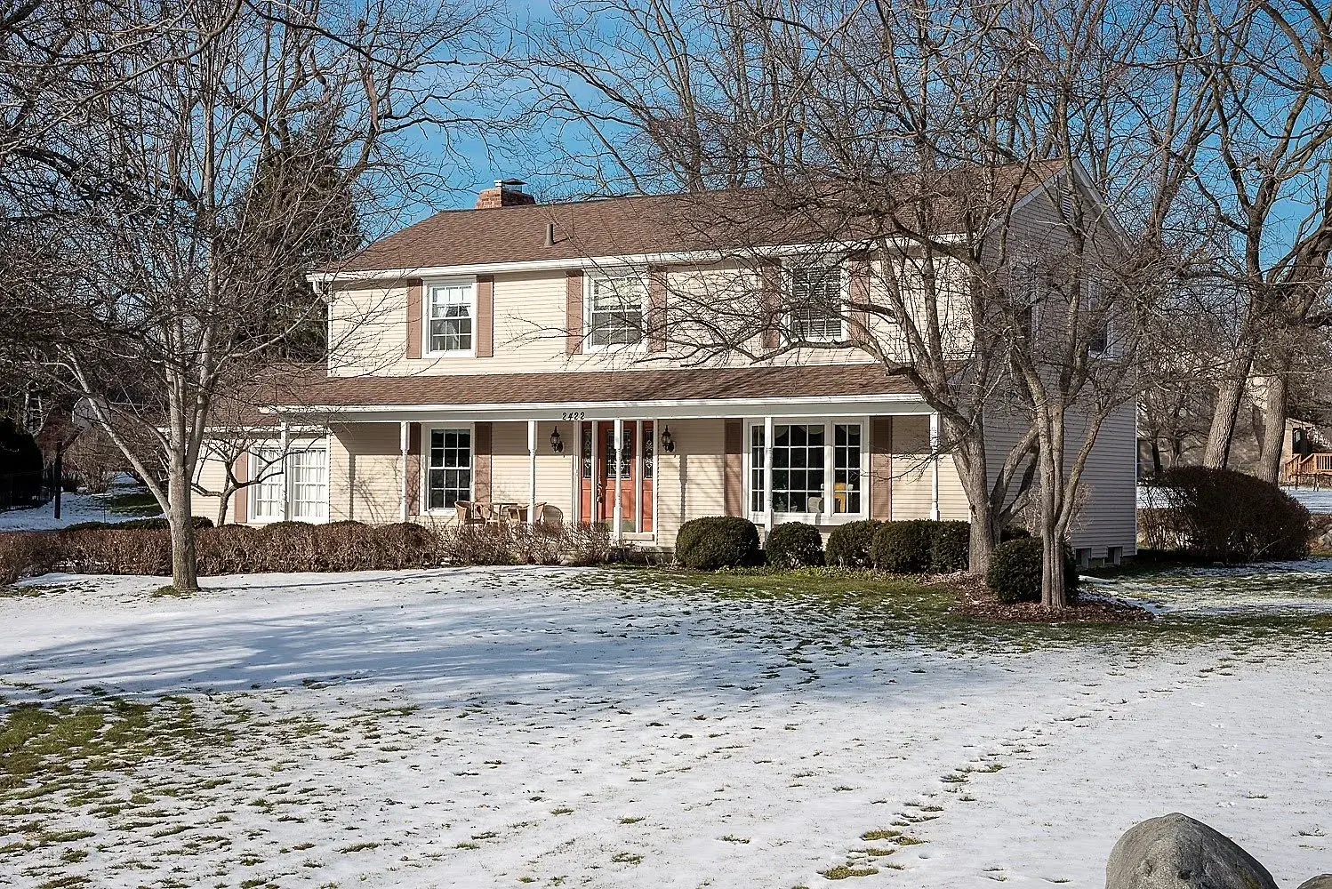 Snowy front lawn view of a home