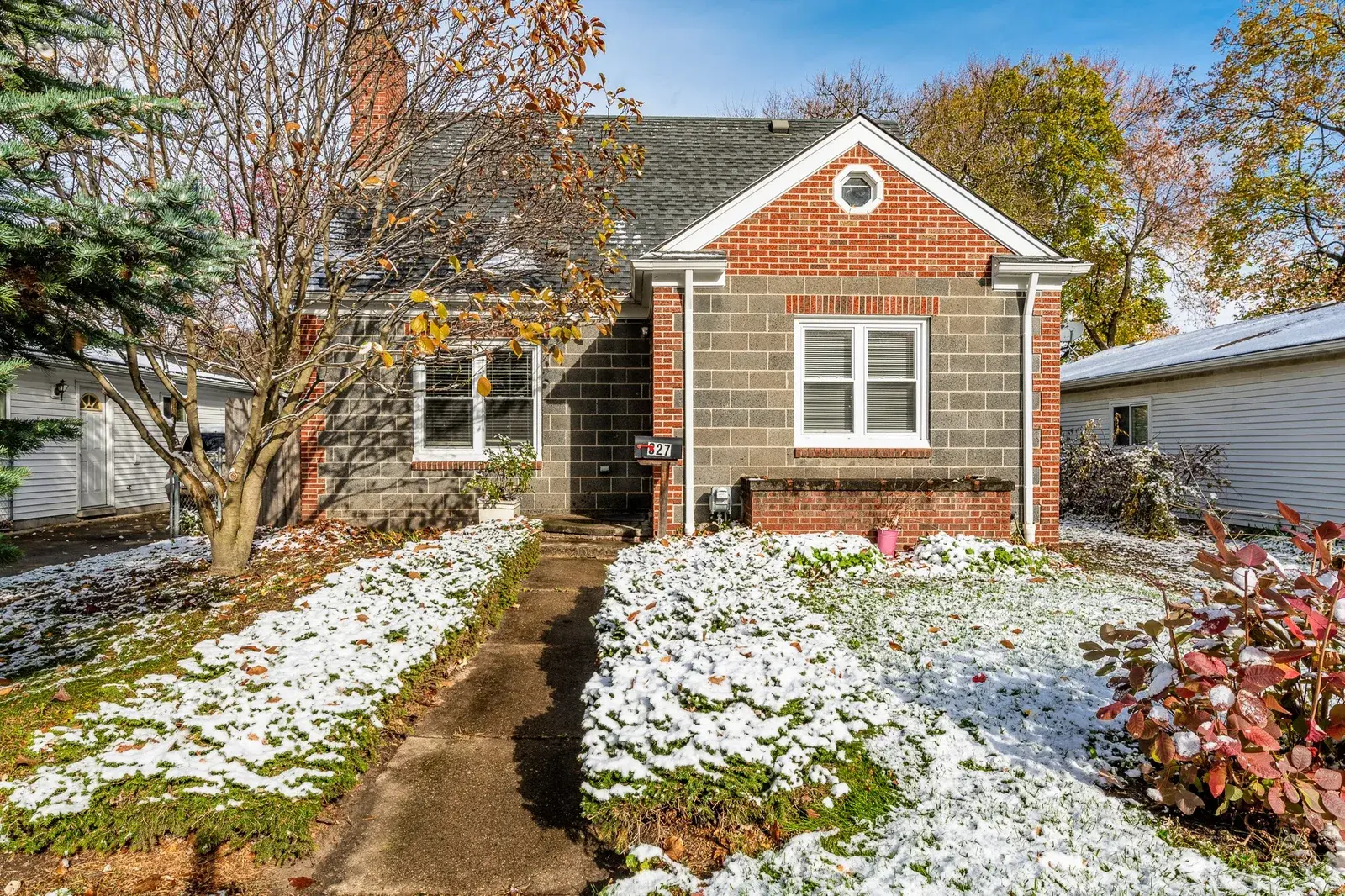 Snowy front lawn view of a home