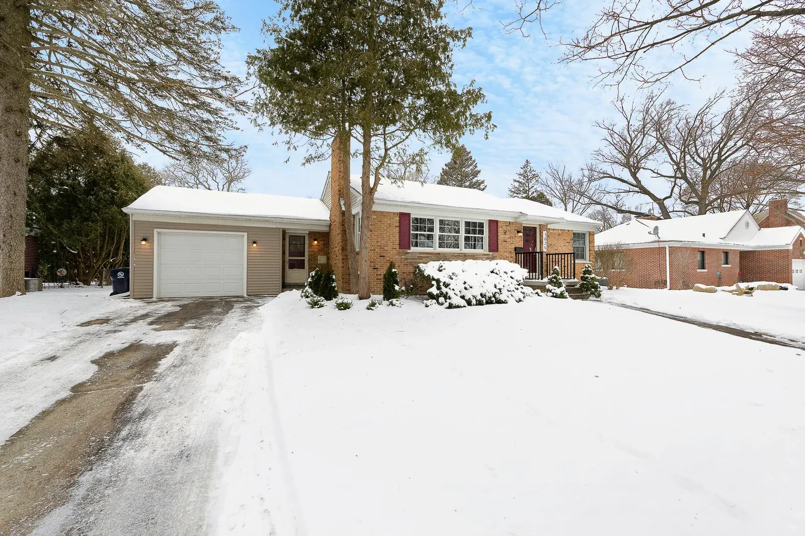 Snowy front lawn view of a home